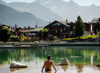 Une personne  est assise dans l'eau au bord du lac